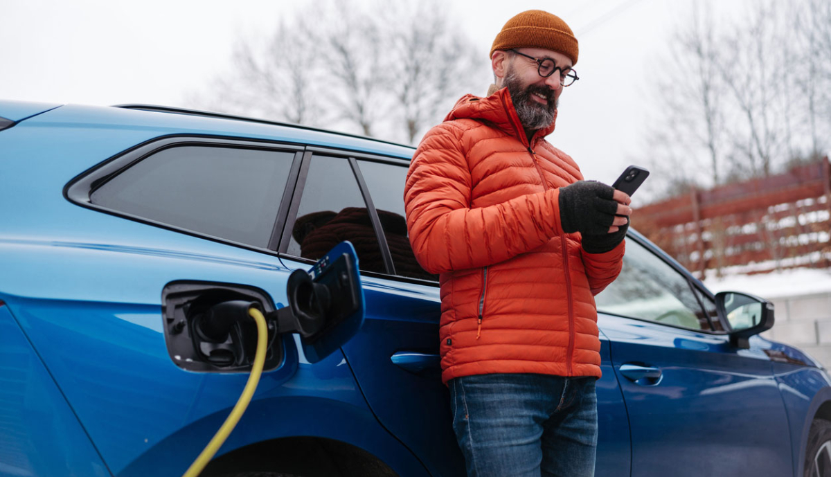 Mann-mit-Elektroauto-und-Handy